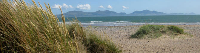 Sand dunes and Newborough Beach on Anglesey, looking across the Menai Strait to the mountains of Snowdonia